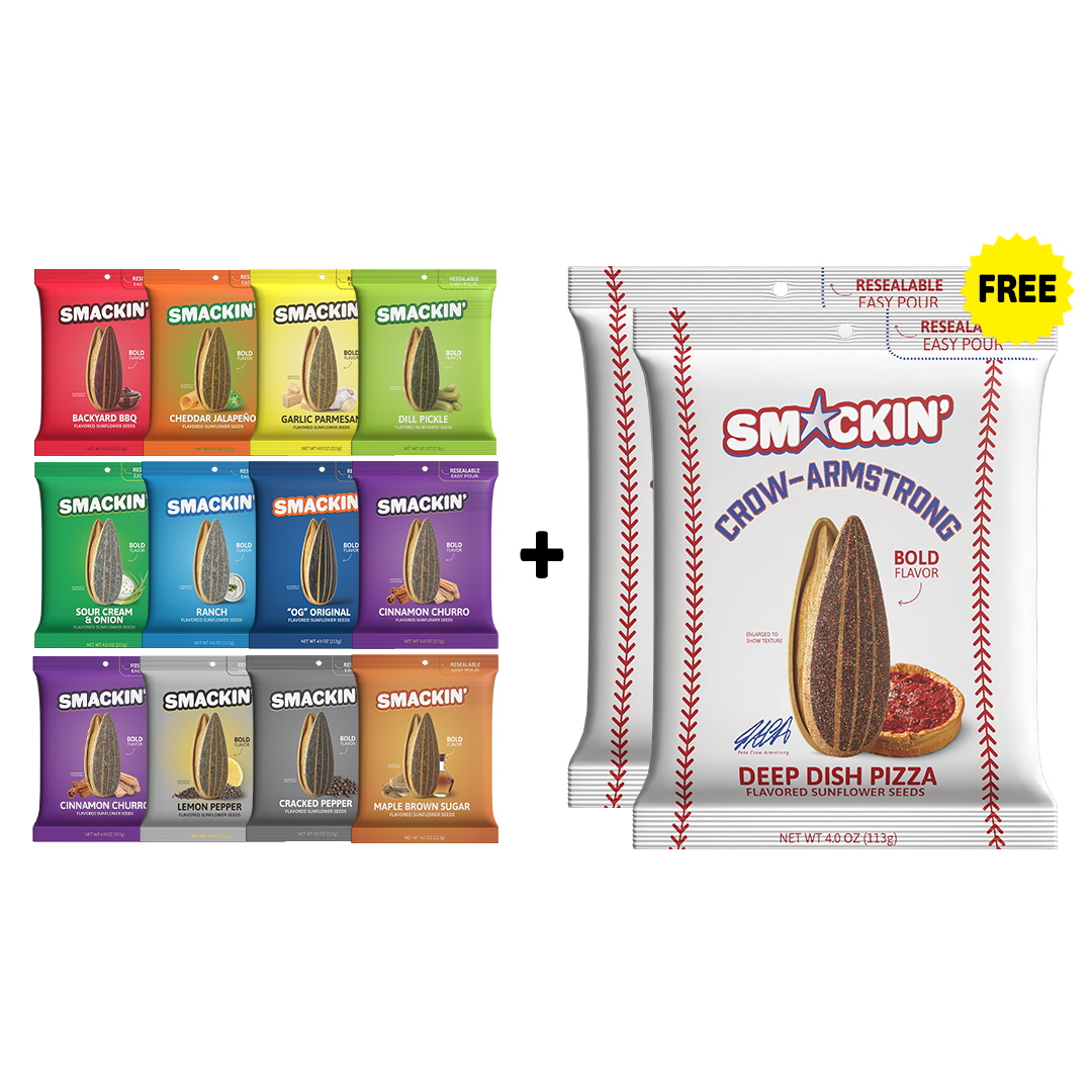 Product photography of a colorful Smakin' sunflower seed variety pack displaying twelve bags in flavors such as red Backyard BBQ, lime green Dill Pickle, and purple Cinnamon Churro, presented alongside two large white baseball-themed Deep Dish Pizza bags with a "FREE" yellow starburst
