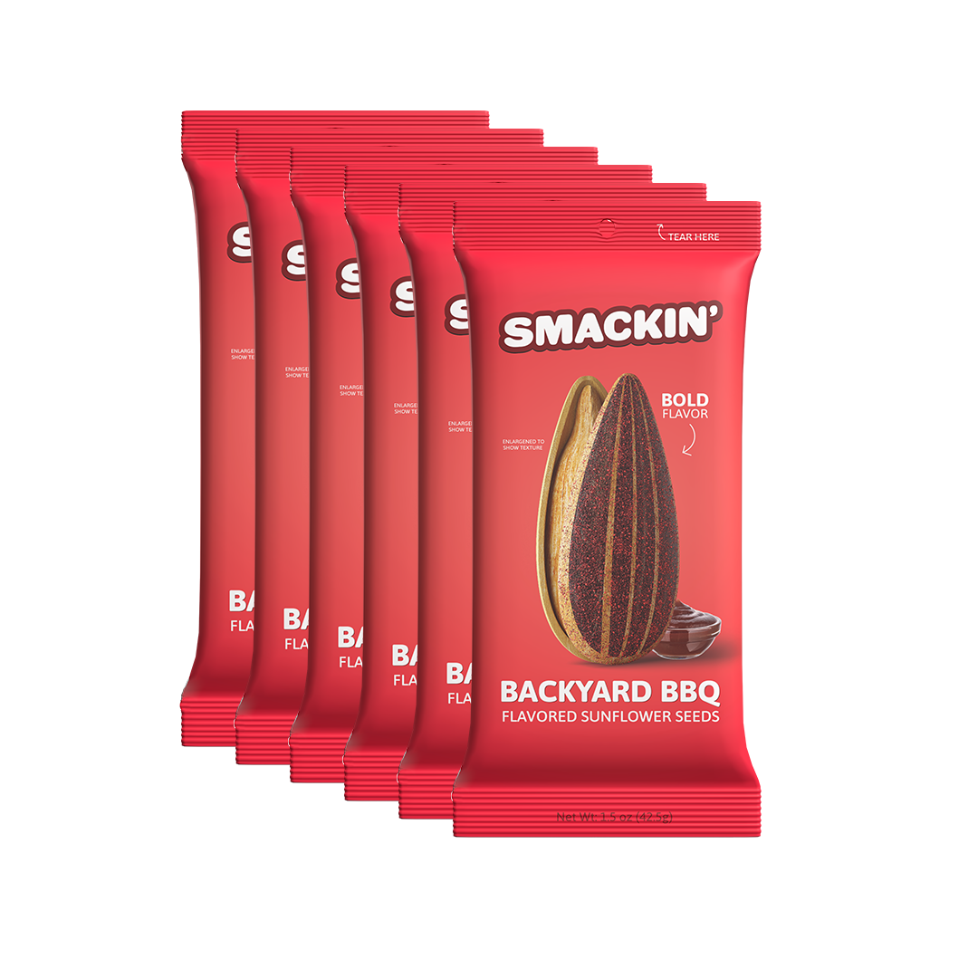 Product photo by Smackin' showcasing six vibrant red "Backyard BBQ" flavored sunflower seed packets, each featuring a large graphic of a split, richly seasoned sunflower seed and a small bowl of barbecue sauce, emphasizing "Bold Flavor"