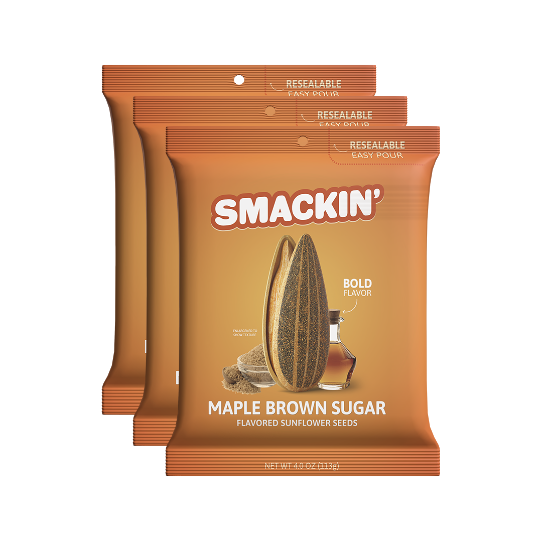 Product photography of three orange Smackin' Maple Brown Sugar Flavored Sunflower Seeds bags featuring a resealable easy-pour top, a large sunflower seed graphic, and depictions of maple syrup with brown sugar