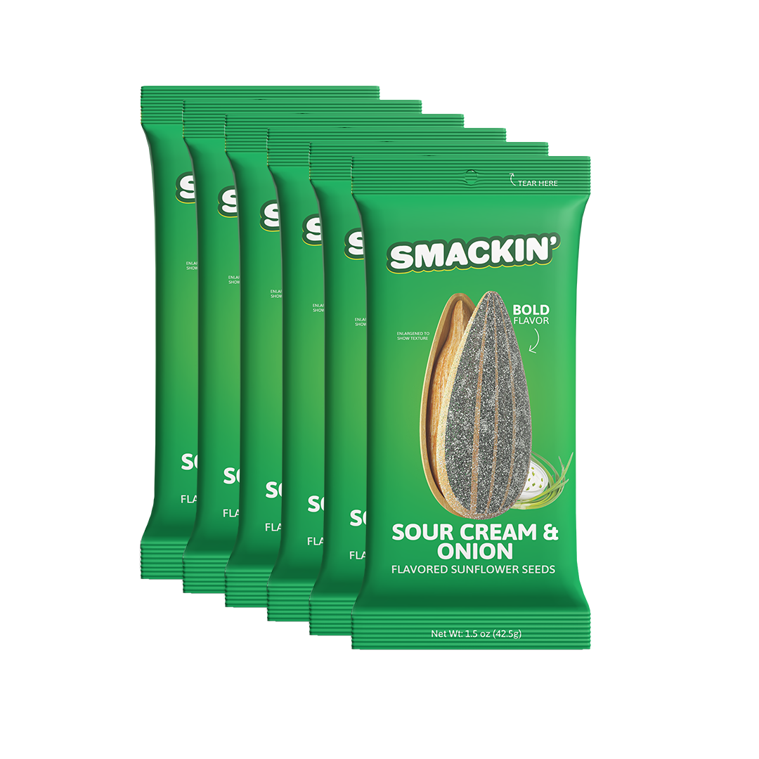 A fanned stack of six vibrant green Smakin' Sour Cream & Onion flavored sunflower seed bags displaying an enlarged sunflower seed and fresh green onions