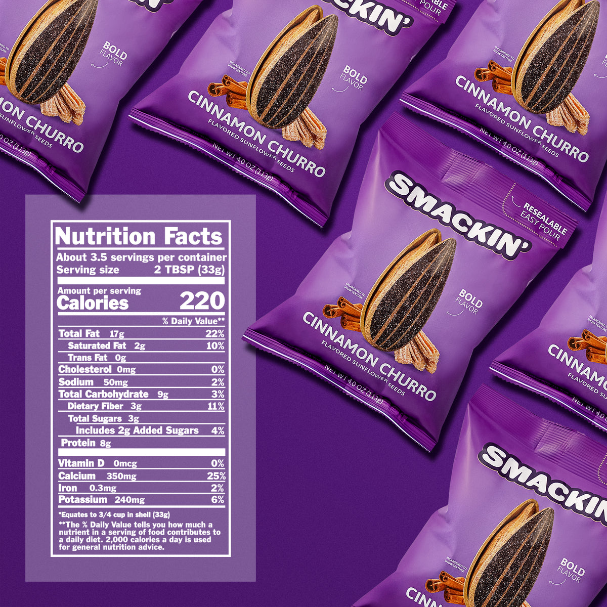 Product photography of multiple purple Smackin' Cinnamon Churro flavored sunflower seed bags featuring a large embellished sunflower seed, churros, and cinnamon sticks, with visible 'Bold Flavor' and 'Resealable Easy Pour' text, arranged on a vibrant purple surface alongside a clear nutrition facts label displaying 220 calories
