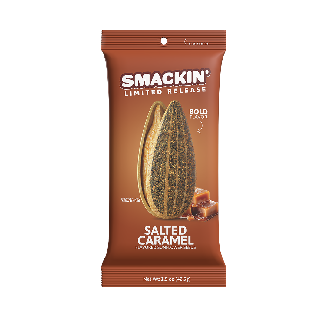 Product photography of a Smackin' Limited Release Salted Caramel Flavored Sunflower Seeds brown snack bag featuring a large split sunflower seed with speckled kernel and a pile of golden caramel squares, indicating bold flavor and 1.5 oz (42.5g) net weight