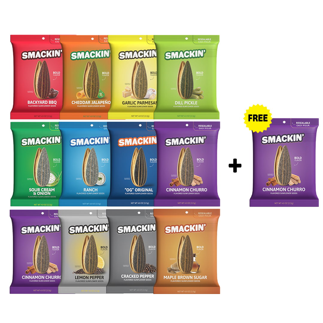 Product photography of a collection of Smackin' Flavored Sunflower Seeds bags showcasing 12 distinct flavor varieties including Backyard BBQ, Dill Pickle, and Cinnamon Churro, with an additional free bonus Cinnamon Churro bag