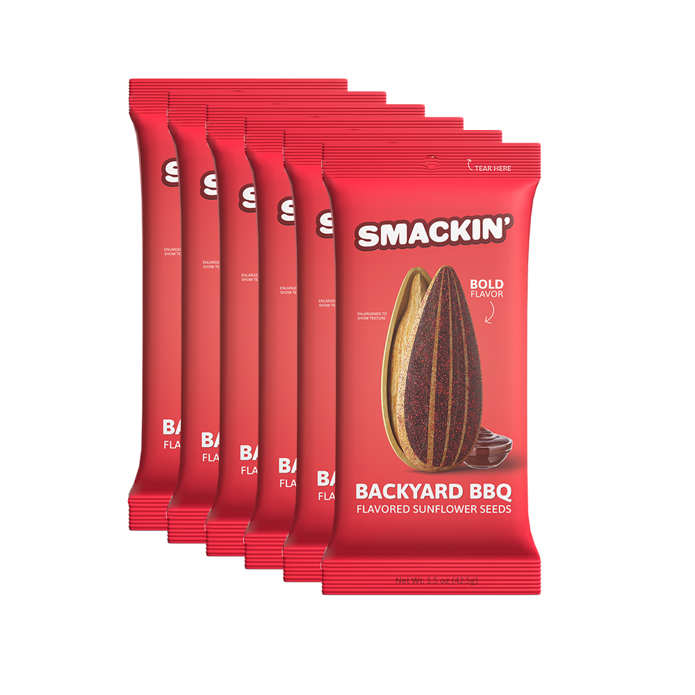 Product photo by Smackin' showcasing six vibrant red "Backyard BBQ" flavored sunflower seed packets, each featuring a large graphic of a split, richly seasoned sunflower seed and a small bowl of barbecue sauce, emphasizing "Bold Flavor"