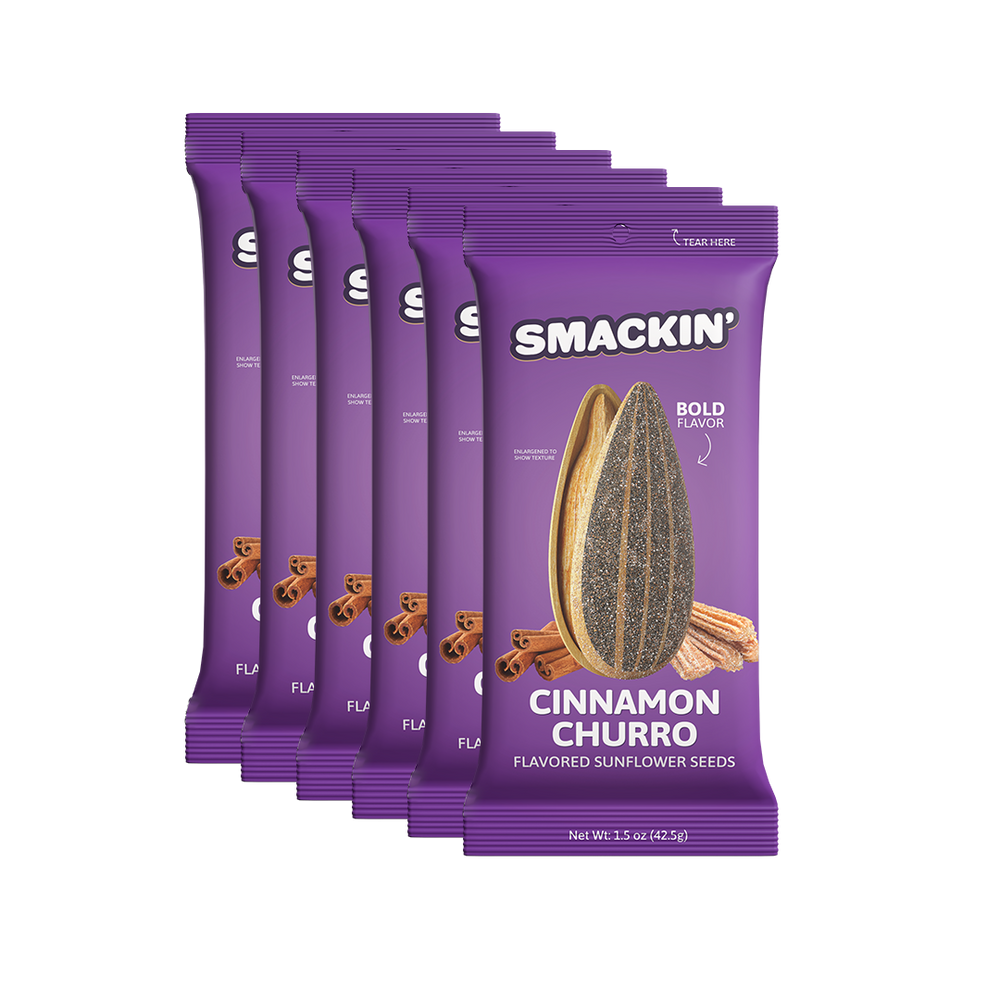 Digital product photography of a stack of five purple Smakin' Cinnamon Churro flavored sunflower seed bags against a clean white background prominently displaying an enlarged sunflower seed, cinnamon sticks, and churros on the label with bold BOLD FLAVOR text