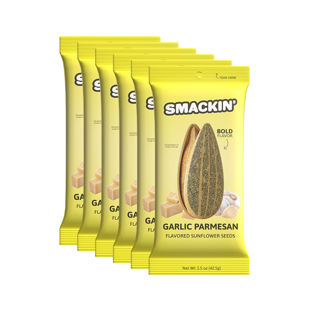 Product photography of six bright yellow Smackin' Garlic Parmesan Flavored Sunflower Seeds packets on a white background, featuring an enlarged sunflower seed, parmesan cheese cubes, and garlic cloves with a 'Bold Flavor' indicator