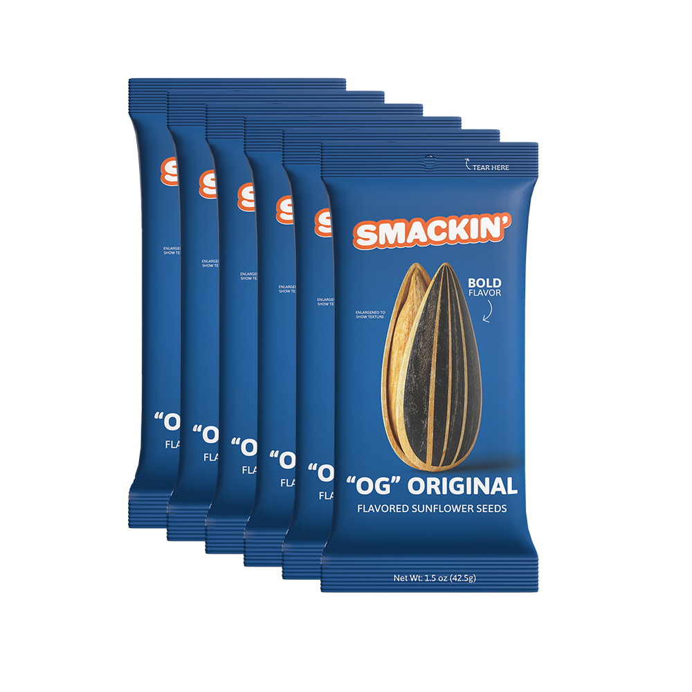 Six dark blue Smackin' 'OG' Original flavored sunflower seed pouches stacked, each prominently displaying an orange logo and two large striped sunflower seeds with 'BOLD FLAVOR' text