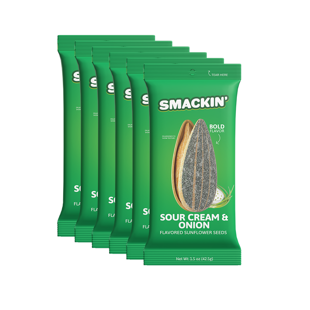 A fanned stack of six vibrant green Smakin' Sour Cream & Onion flavored sunflower seed bags displaying an enlarged sunflower seed and fresh green onions