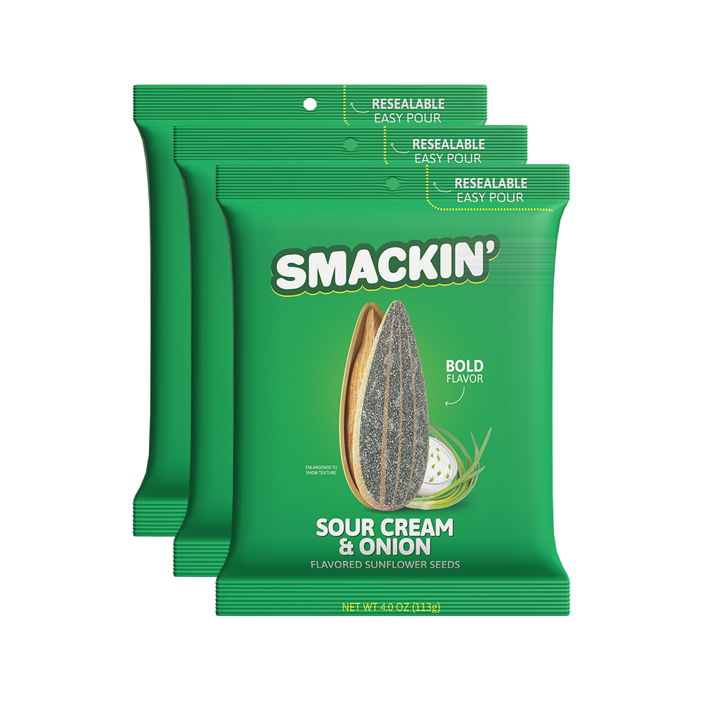 Product photography of three vibrant green Smakin' Sour Cream & Onion flavored sunflower seed bags featuring a detailed illustration of a large sunflower seed and sour cream with chives along with "Resealable Easy Pour" tops