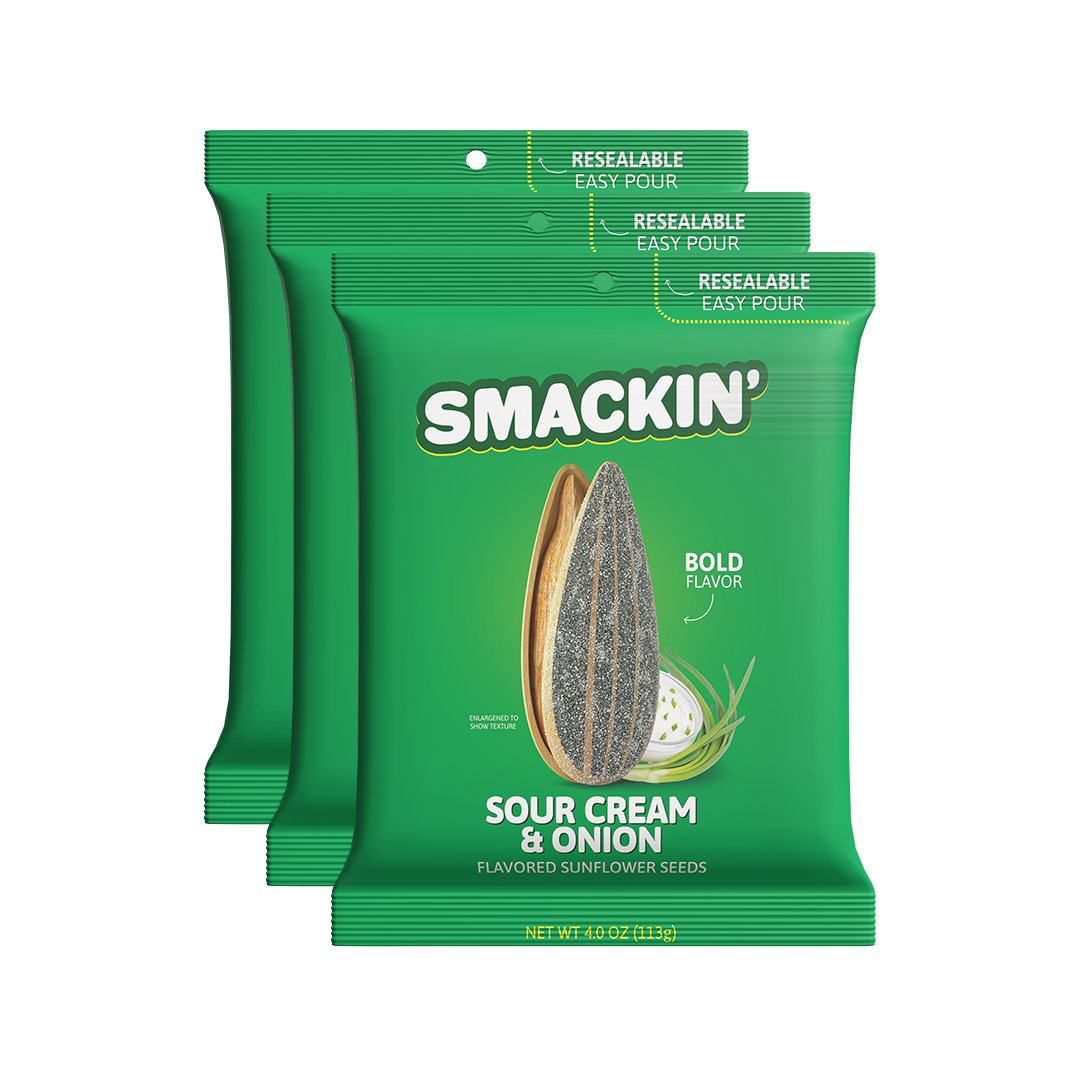 Product photography of three vibrant green Smakin' Sour Cream & Onion flavored sunflower seed bags featuring a detailed illustration of a large sunflower seed and sour cream with chives along with "Resealable Easy Pour" tops